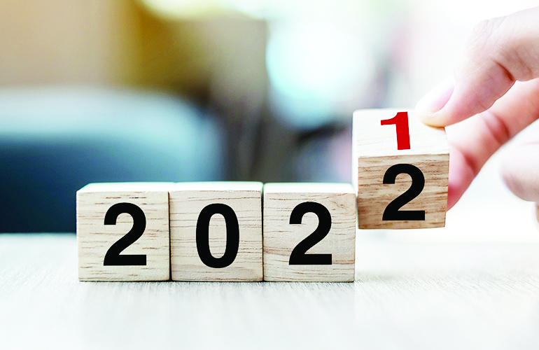 Businessman hand holding wooden cube with flip over block 2021 t